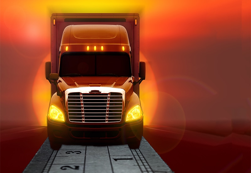 A freight truck with a ruler showing the last inch.